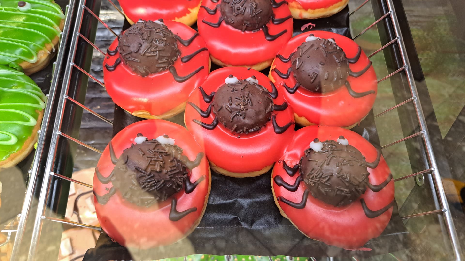 Spider doughnuts with red icing in a bakery display